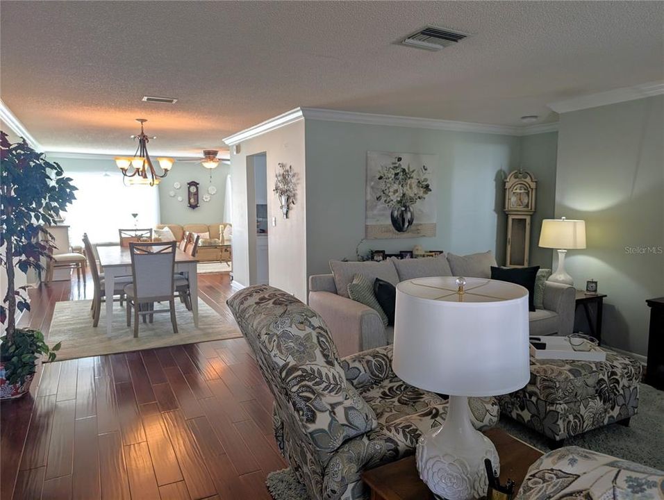 Open concept view of kitchen surrounded by living, dining and Florida rooms.  Split floor plan with guest bedroom & main bath to right.  The primary ensuite is to left (not visible).