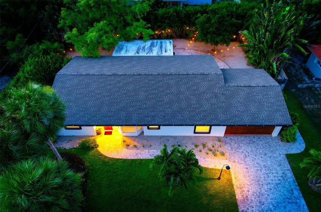 The home is enveloped in tropical landscaping.