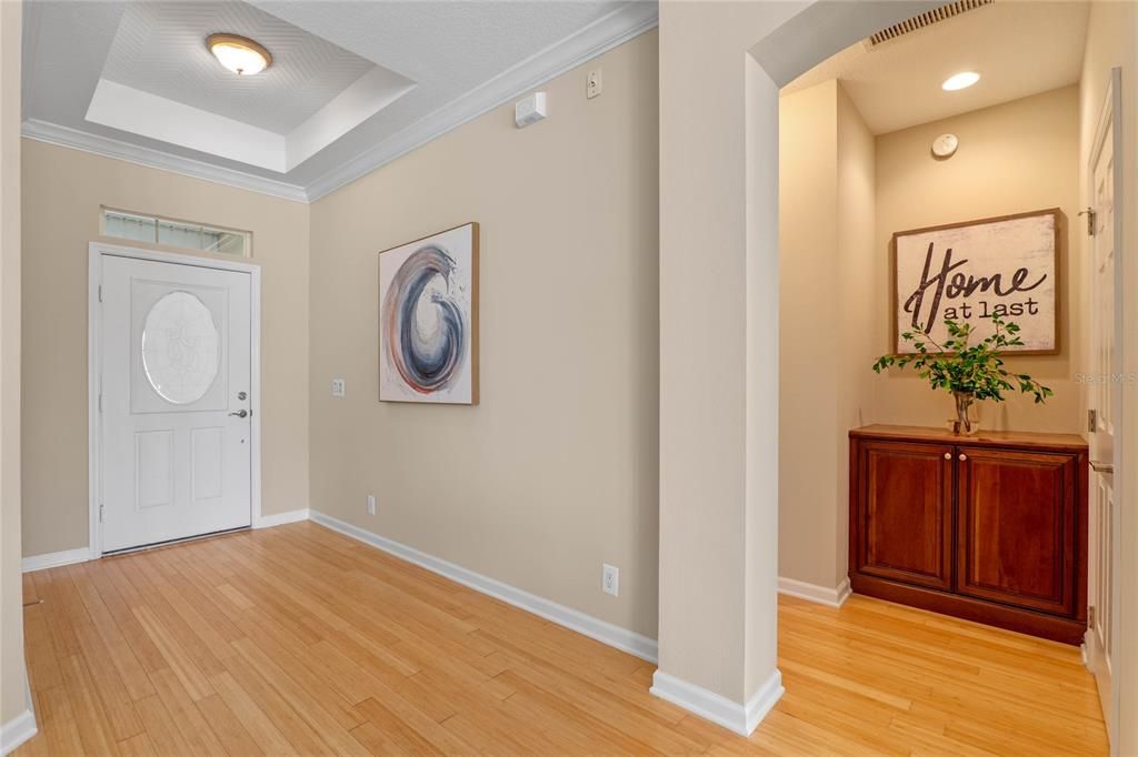 Foyer entryway w/ Bamboo floors, leaded glass front door, tray ceiling & crown molding