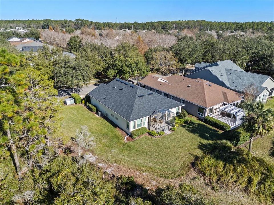 Aerial view from behind the home w/ a conservation area along the right side