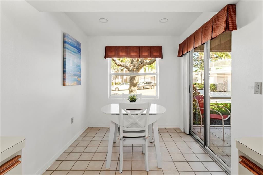 Informal dining space off of the kitchen with a glass sliding door to a private, screened-in patio