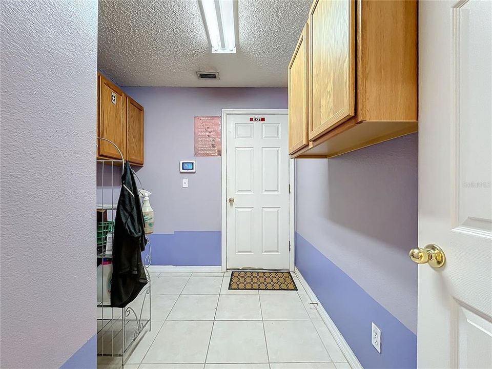 Inside laundry room with cabinets for storage is attached to the garage.