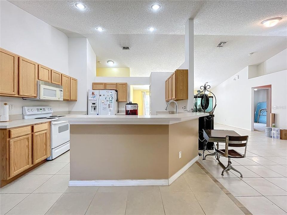 Kitchen has plenty of cabinets and bar seating for enjoying less formal meals.