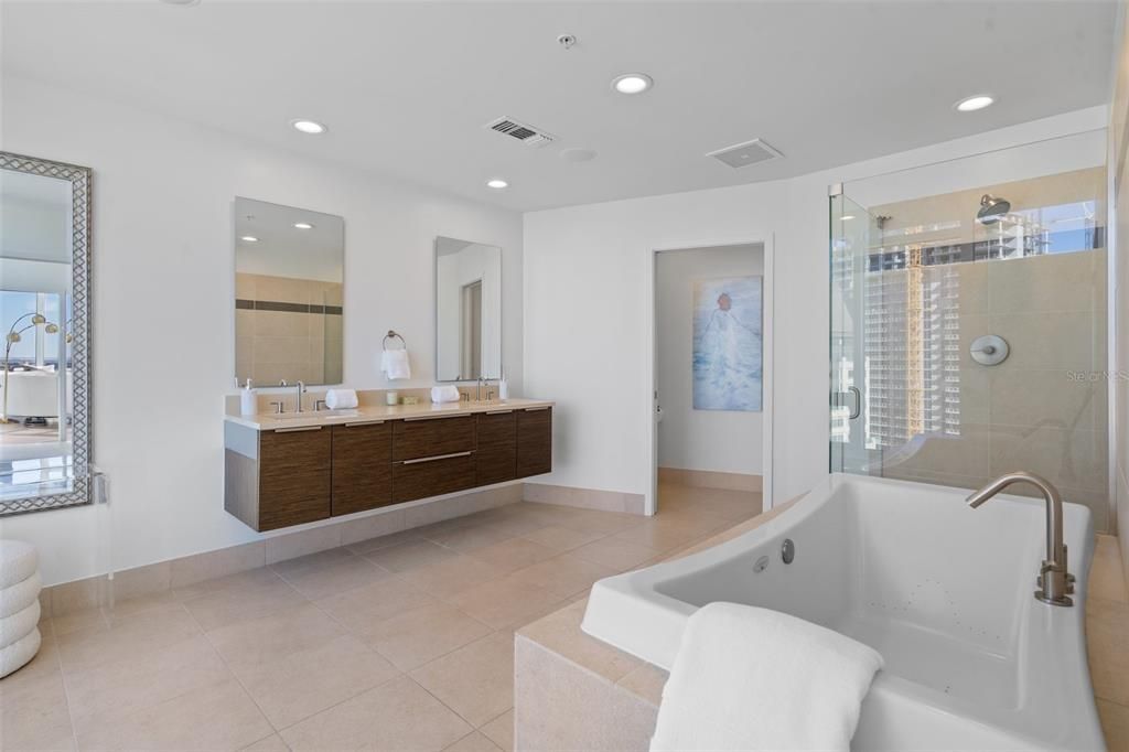 Ensuite guest bathroom has double sinks, a separate soaking tub, and enough room or a makeup vanity.