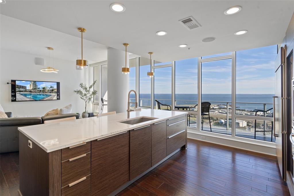 The kitchen is complete with quartz countertops, custom cabinetry, and a grand island with seating spaces.