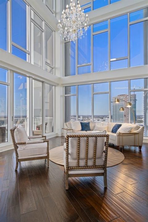 Natural light bathes the living area with floor-to-ceiling windows that are equipped with electric shades.