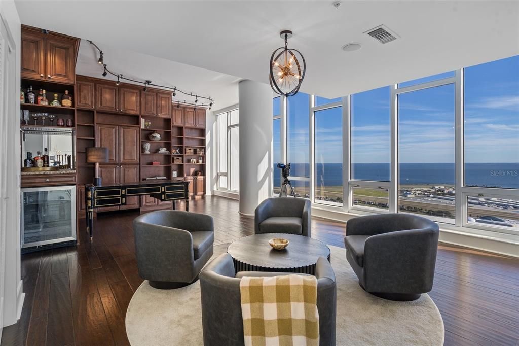 The office has plenty of built-in cabinetry for storage, including a mini fridge and dry bar area.