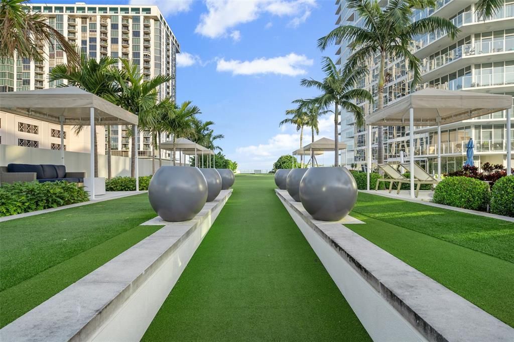 Lush landscaping on the pool deck includes gas grills.