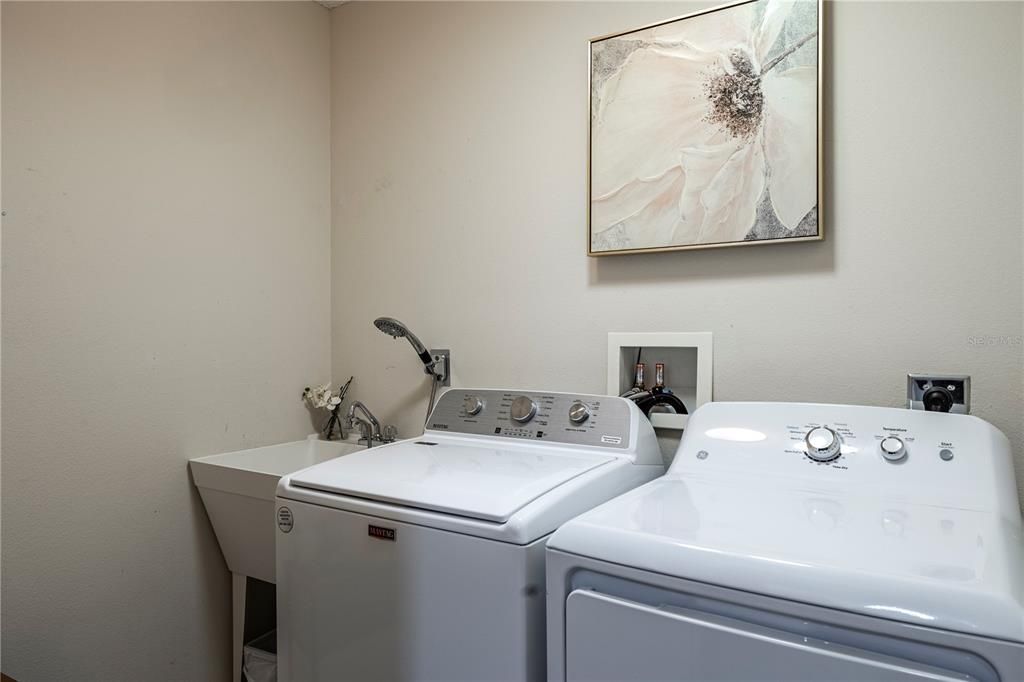 INDOOR LAUNDRY AREA WITH A WET SINK AND A LINEN CLOSET OUTSIDE THE POCKET DOOR