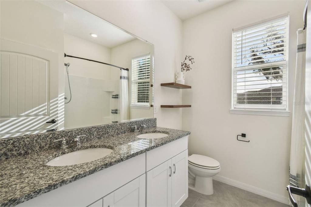 Bathroom 3, located between bedrooms 3 and 4, features a double vanity and a tub/shower combo.