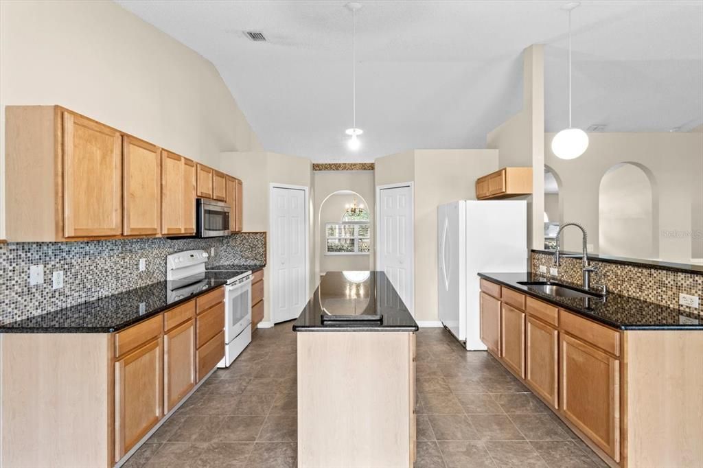 Kitchen w/ Granite Countertops, Mosaic Backsplash, 2 Pantries, Center Island & Breakfast Bar