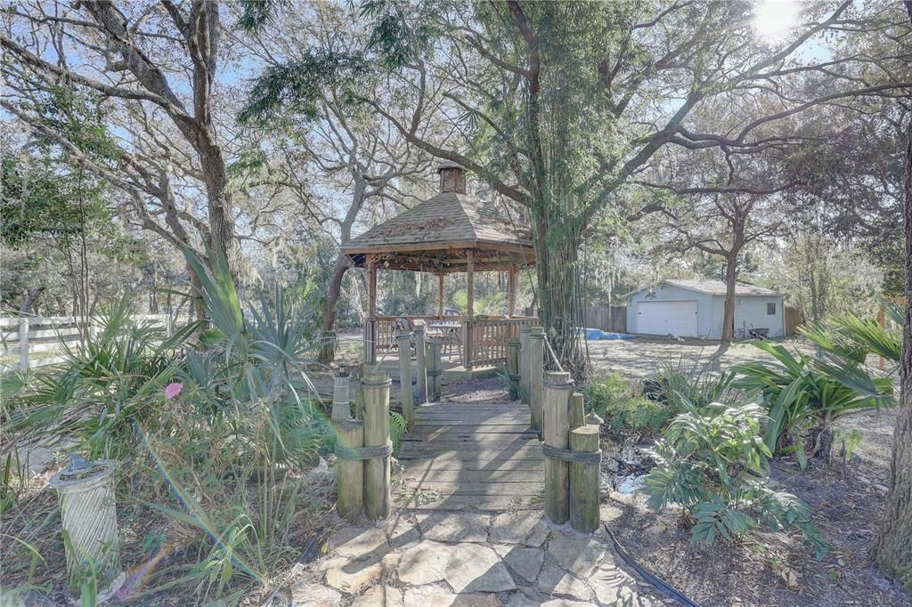 Wooden bridge over the pond leading to gazebo