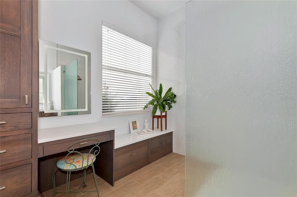 Primary bath w/ample cabinet storage and dressing table.