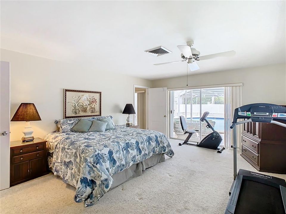 Primary bedroom with sliding glass doors leading to the pool