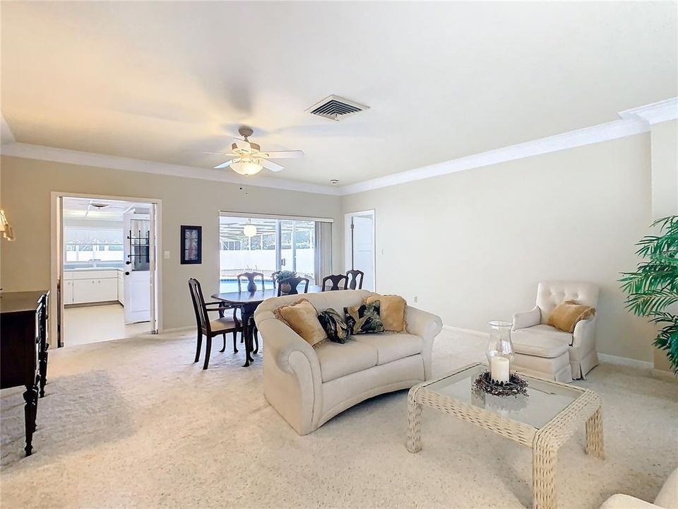 Living room / dining room with open view to the screened pool/lanai area.