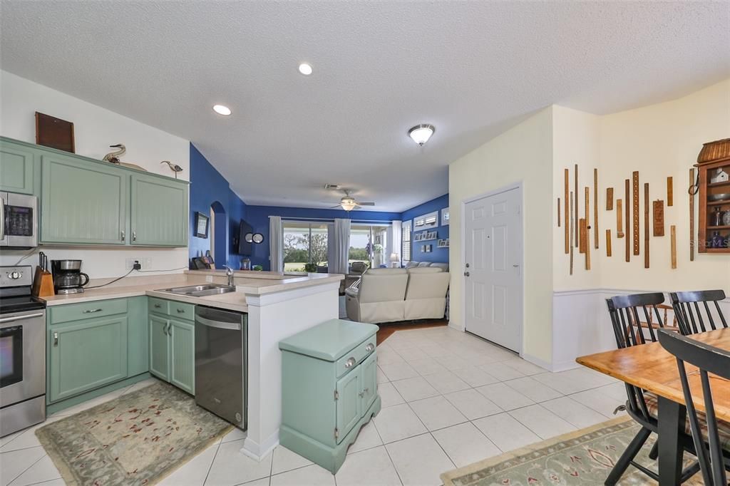 The Kitchen looks over the dining and living rooms as an open floor plan. The cabinets are painted in the new seasonal color of spring!