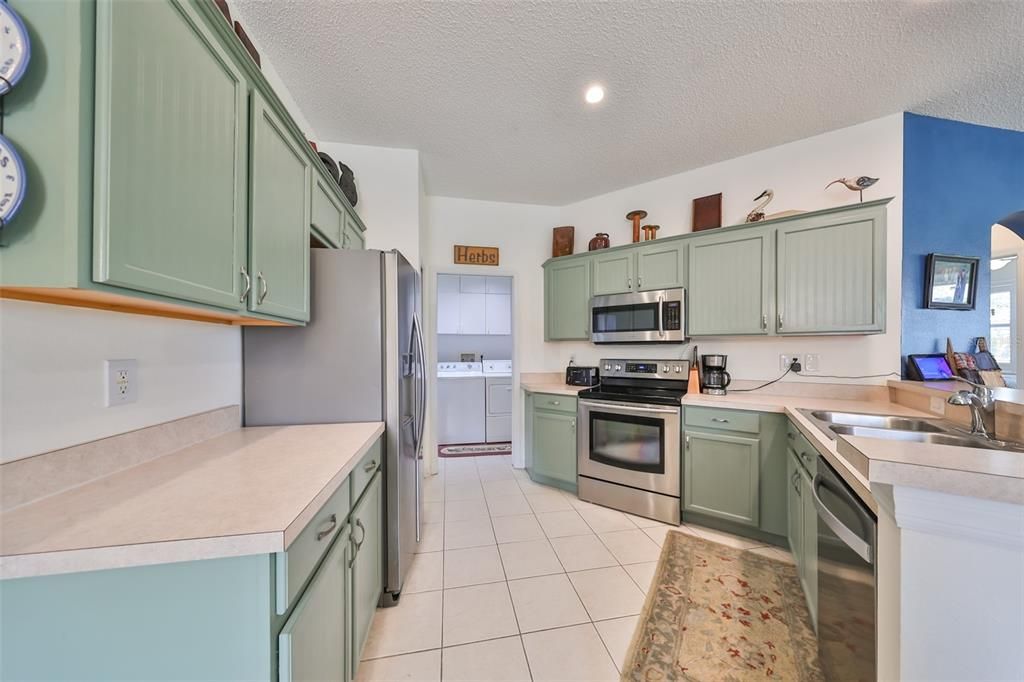 The stylish kitchen offers ample storage with extra counter space. Notice the laundry room is offset from the kitchen in its own space on the way to the double garage.