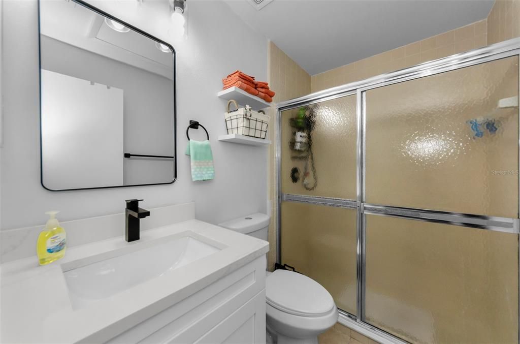 Primary bathroom with new counters, cabinets and mirror. New toilet and fixtures