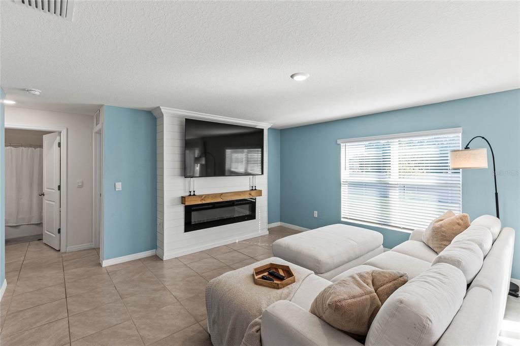 Family room with built in shiplap wall with electric fireplace insert