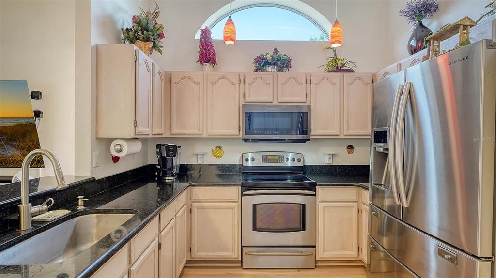 Kitchen w granite counter tops & stainless steel appliances.