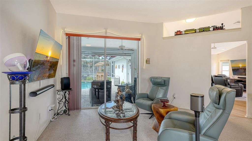 Livingroom w carpet & sliding doors to lanai.