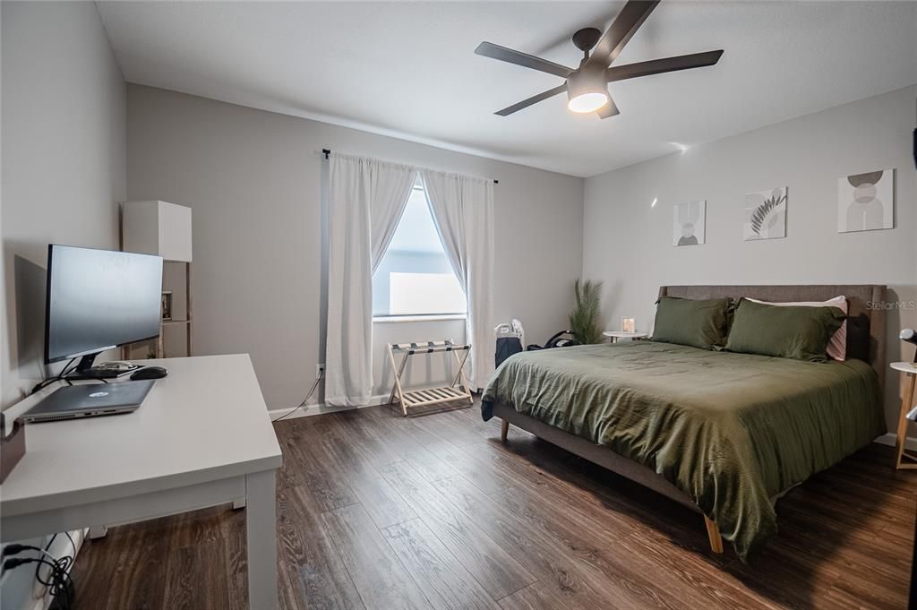 3rd bedroom with luxury plank vinyl and ceiling fan.