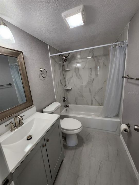 MAIN BATHROOM OFF THE HALLWAY- NEW CABINETRY, TOILET AND SHOWER ENCLOSURE.  LINEN CLOSET INSIDE OF BATHROOM