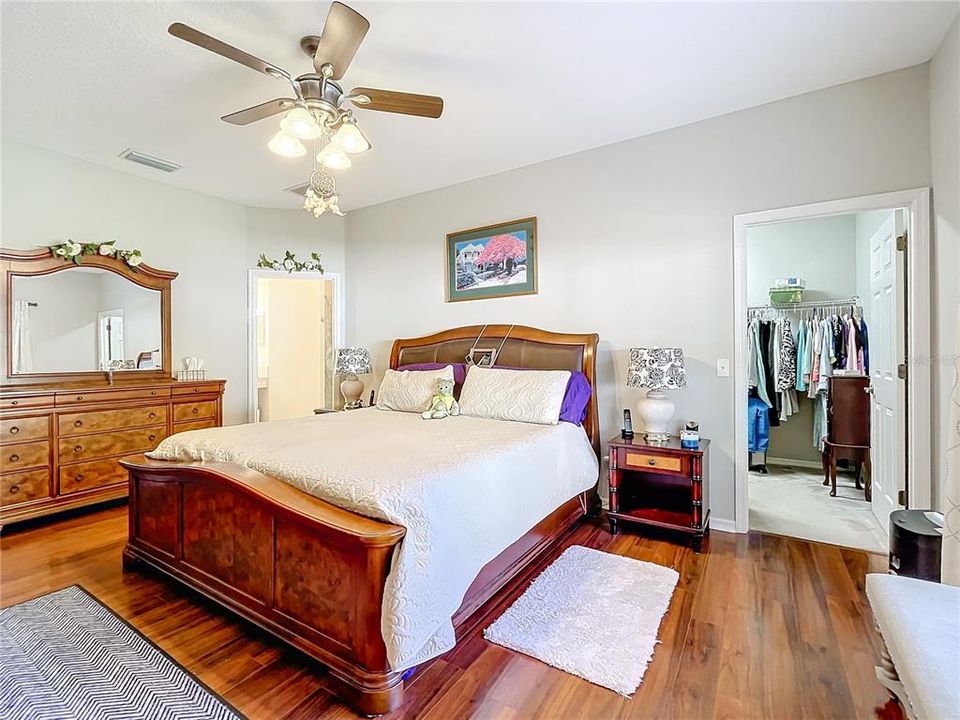 Primary bedroom featuring engineered wood floors, with walk in closet and en-suite bathroom.