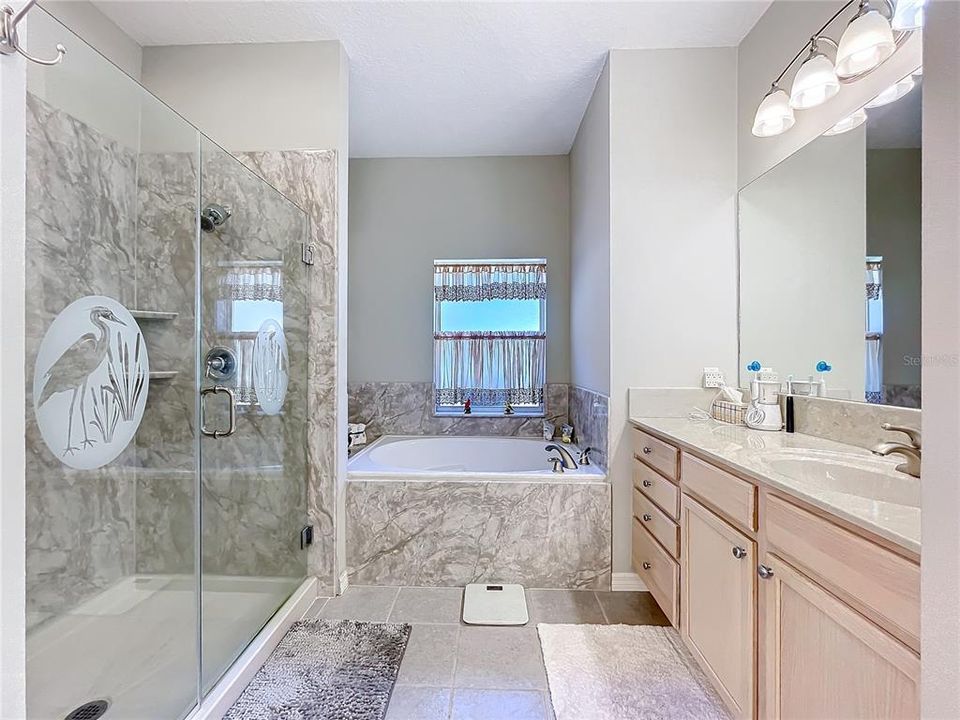 Primary bathroom with soaker tub and separate shower stall.