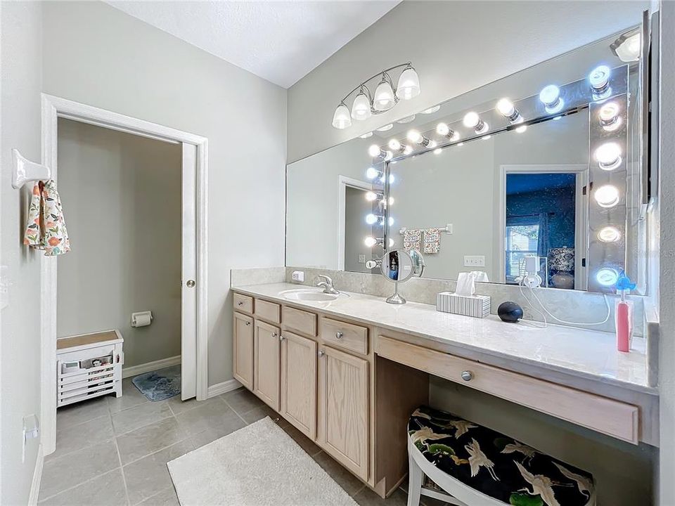 Primary bathroom with make up counter and private toilet closet.