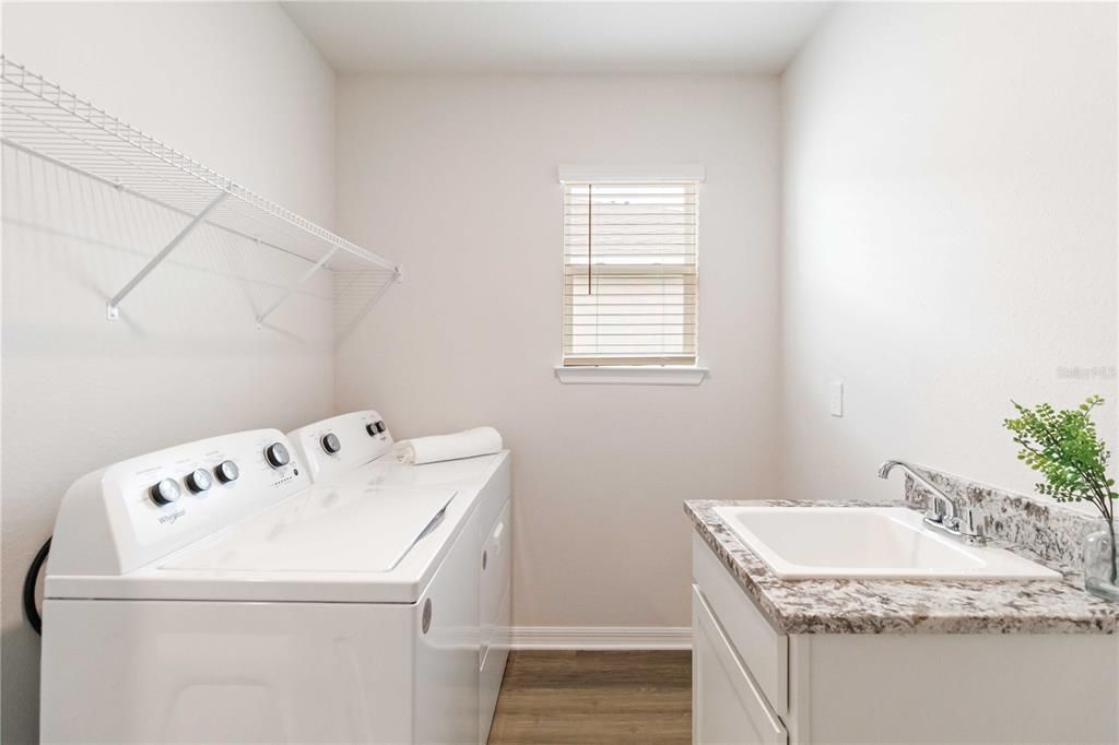 Laundry Room with dual entrance from Owners Suite and Hallway plus wet sink