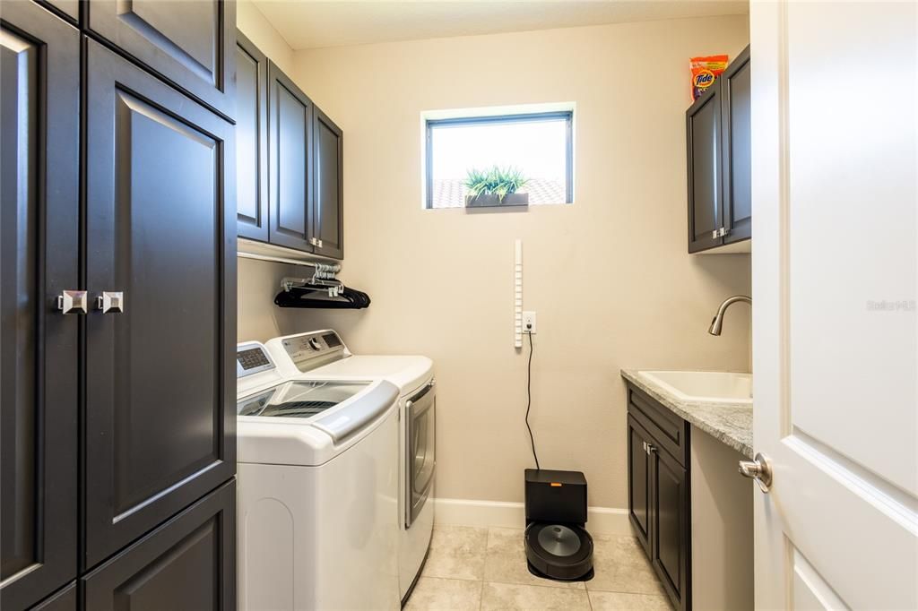 Laundry with built-in cabinetry and sink