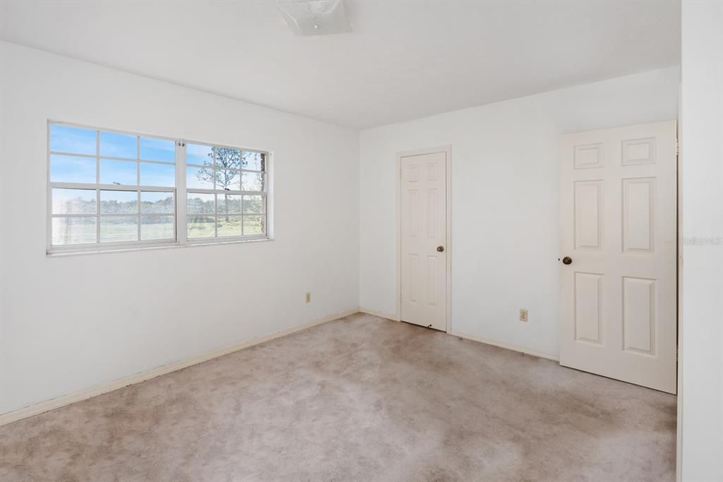 PRIMARY BEDROOM WITH BATHROOM DOOR