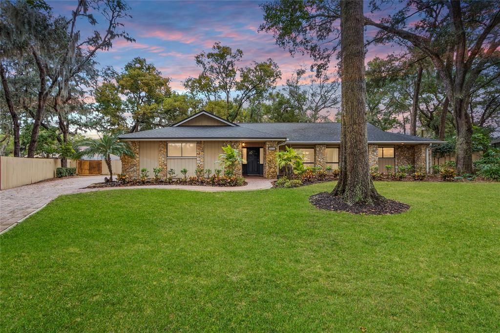 Front of the house - brick paver driveway and mature landscape