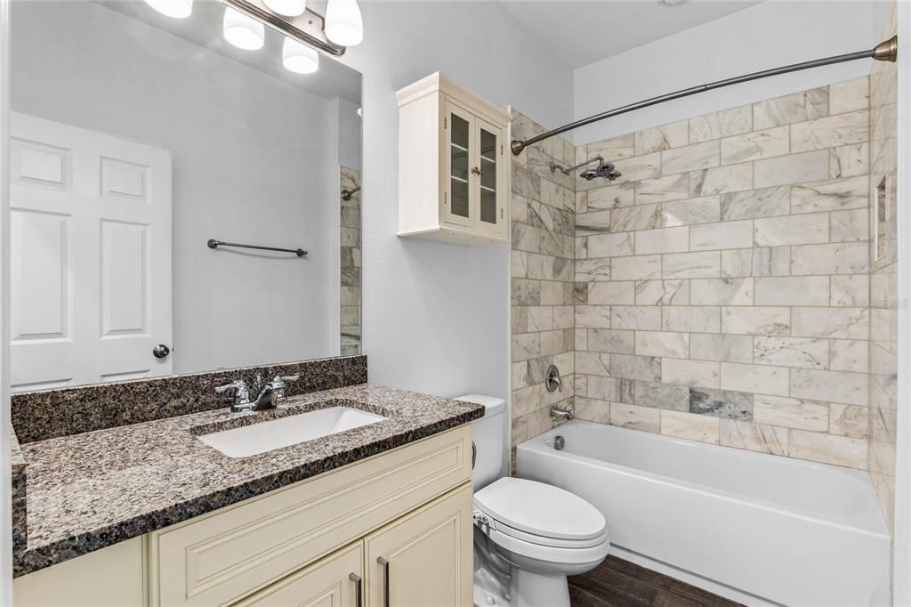 Secondary bath with tub/shower combo and large single vanity.