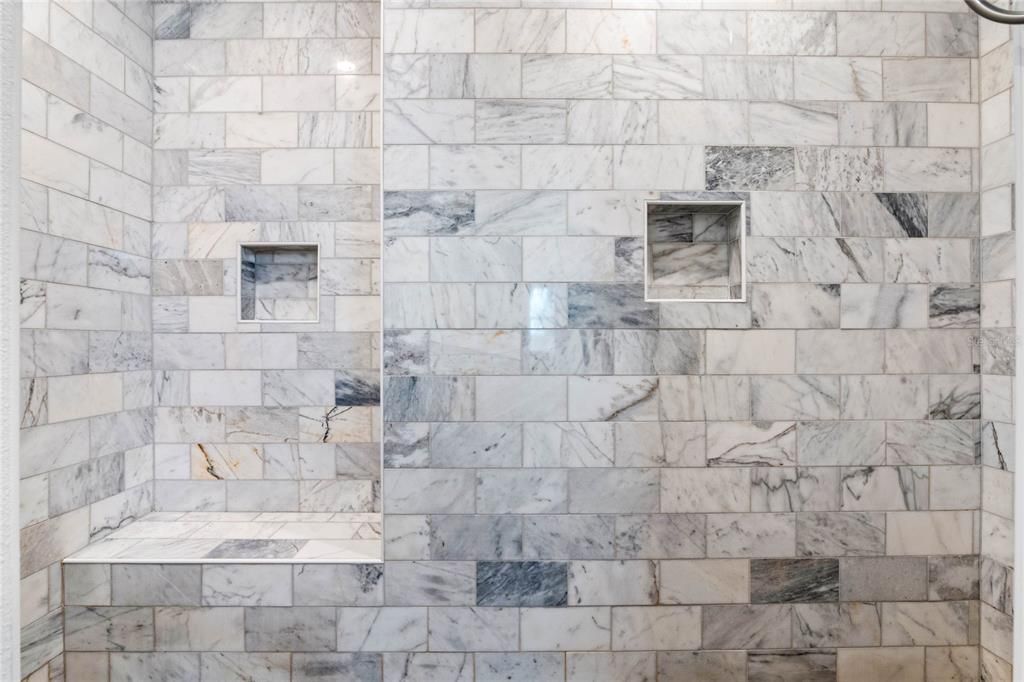 Oversized primary shower with multiple shower heads.