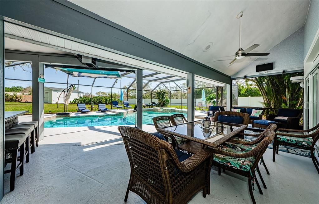 Nice picture of sitting area at poolside and outdoor kitchen.