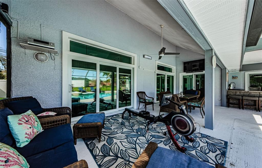 Lounge, table sitting area and outdoor kitchen at poolside.