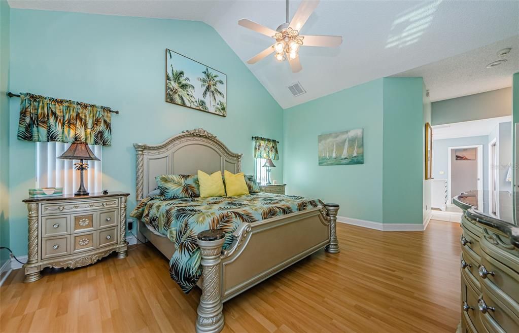 Primary bedroom housing king size bed, wood floors, and easy open access to master bath.