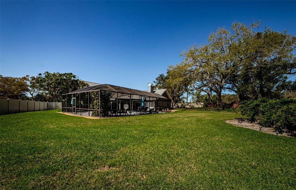 View of large back yard completely fenced and beautifully landscaped.