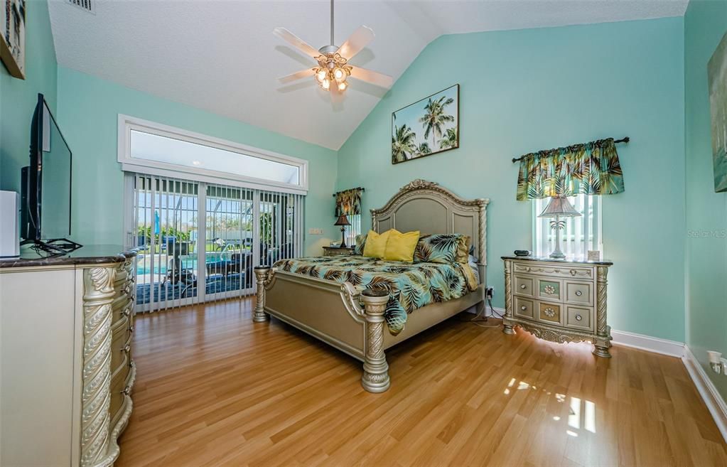 Primary, master bedroom with cathedral ceiling.  Transom window over new sliding doors to pool area.