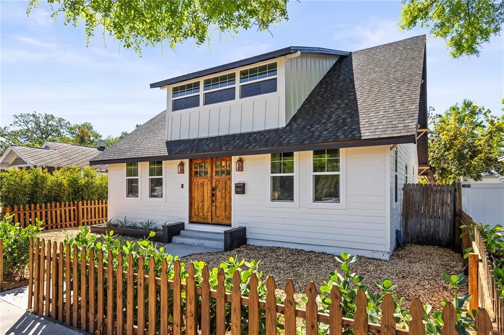 River rocked zero scape yard with fresh landscaping and welcoming picket fence.