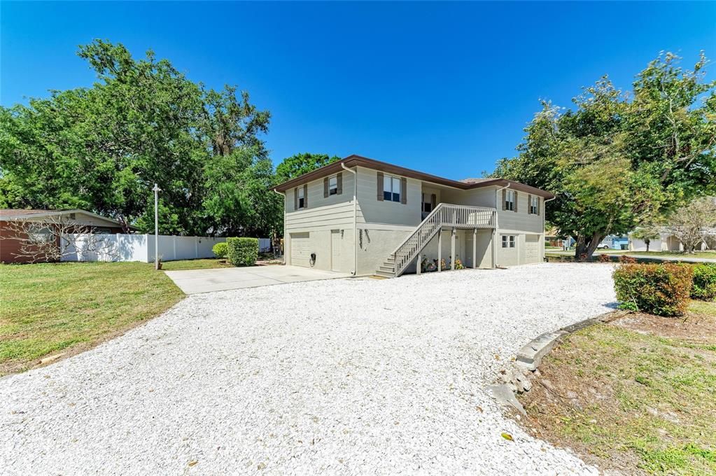 Circle driveway with a parking slab along with 2 garages. Entire first floor is hobby shop, garage, storage area, laundry, etc. Main living area is on second floor with a large front patio.
