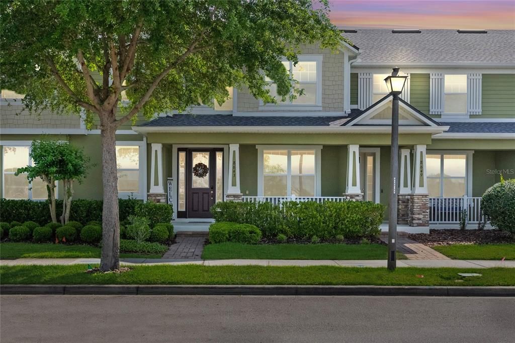 Welcoming entry with a charming front porch and mature landscaping