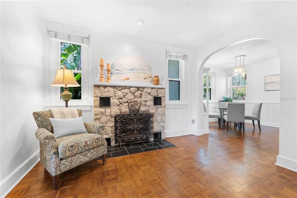 Perfectly maintained wood flooring, a well placed archway, and a fireplace make this space feel timeless