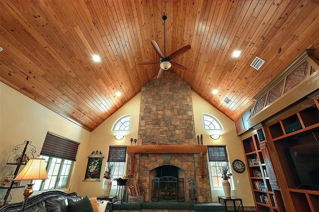 This stunning great room exudes warmth and rustic elegance with it's soaring vaulted ceiling clad in rich tongue-and-groove wood planks. Dramatic stone fireplace with solid wood mantel.