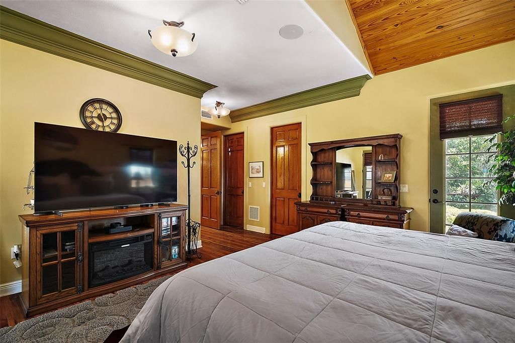 primary bedroom with two rustic wood doors leading to walk in closets containing built in storage