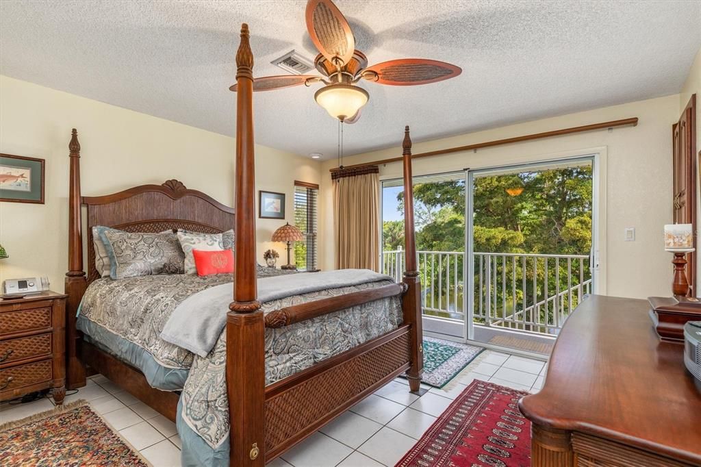Primary bedroom has a balcony overlooking the canal and luscious backyard