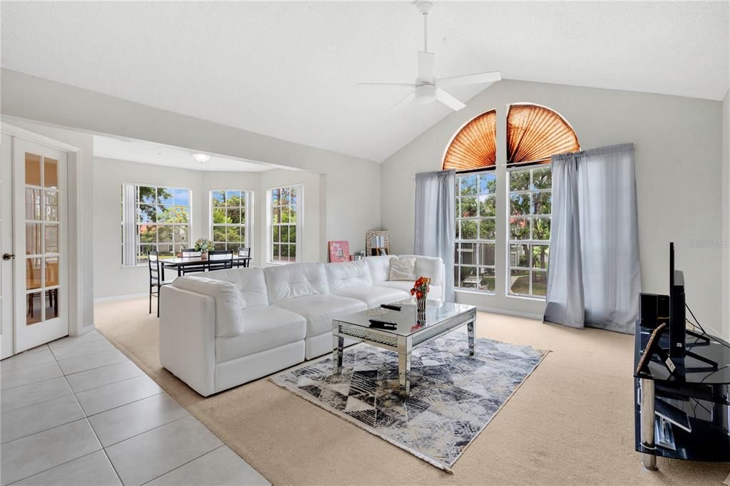The living room with oversized windows facing the parking lot towards the west