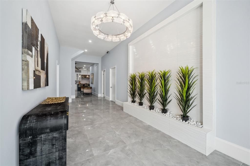 View of the foyer with shiny tile floors, high ceilings and modern touches